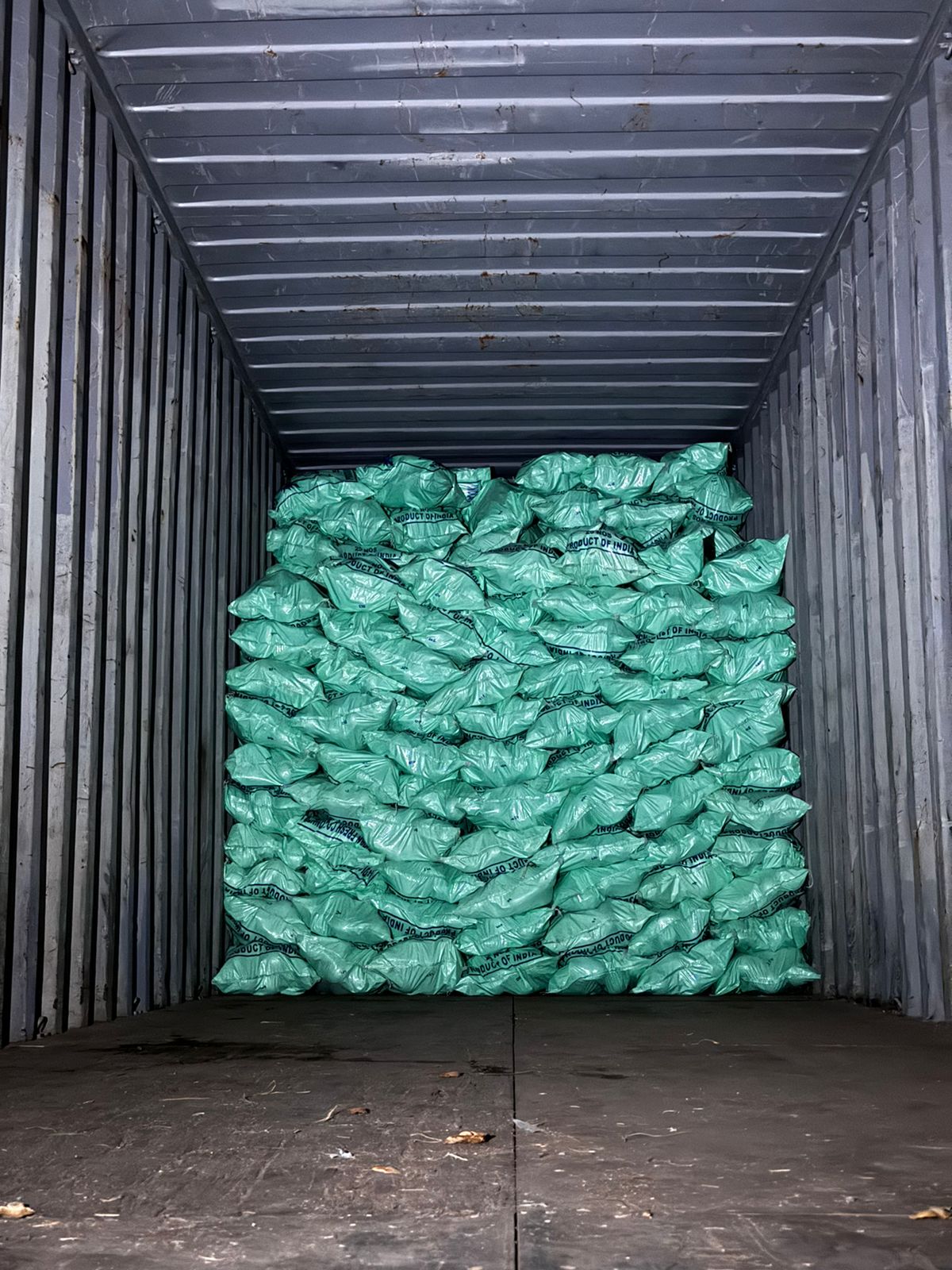 Bags of fresh coconuts stacked to the roof of a container