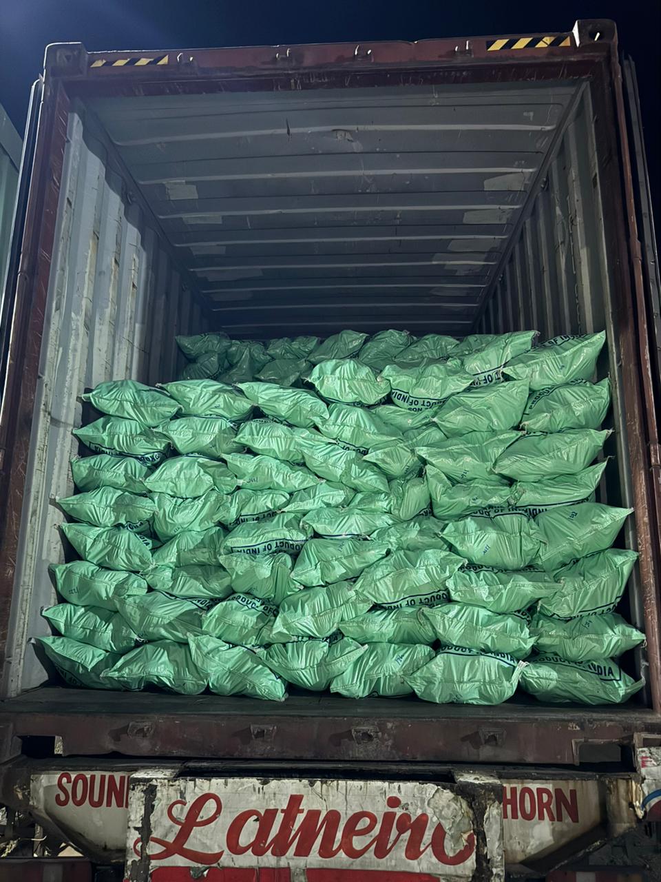 Coconut bags loaded into a container at night