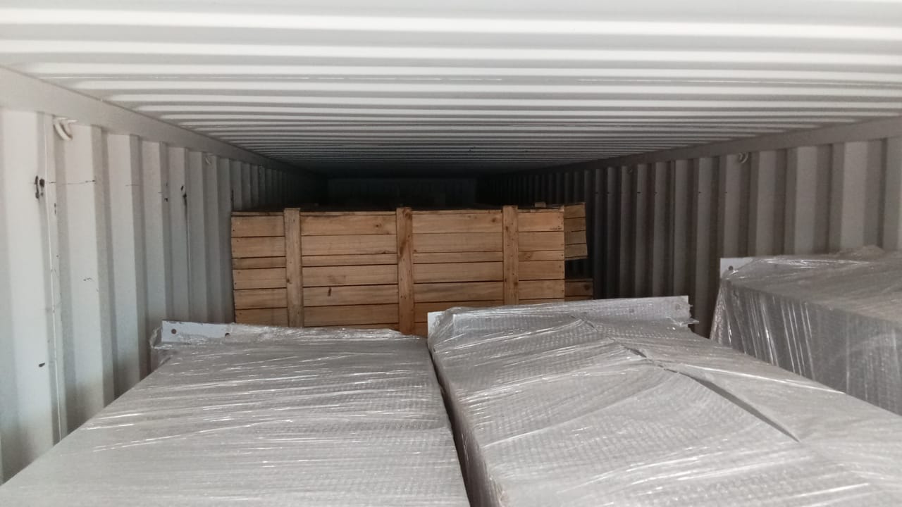 Wrapped machinery and a timber crate loaded inside a container