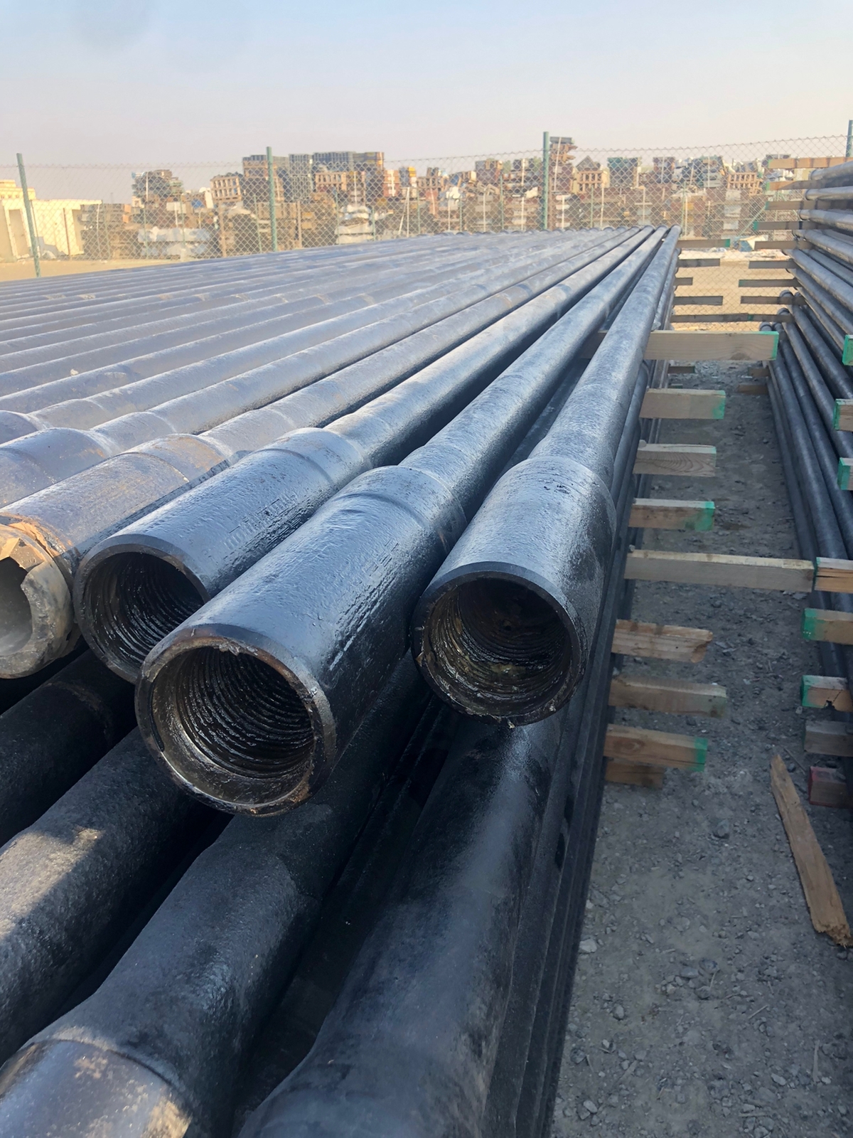 Drill pipes stacked on timber bearers at a cargo yard