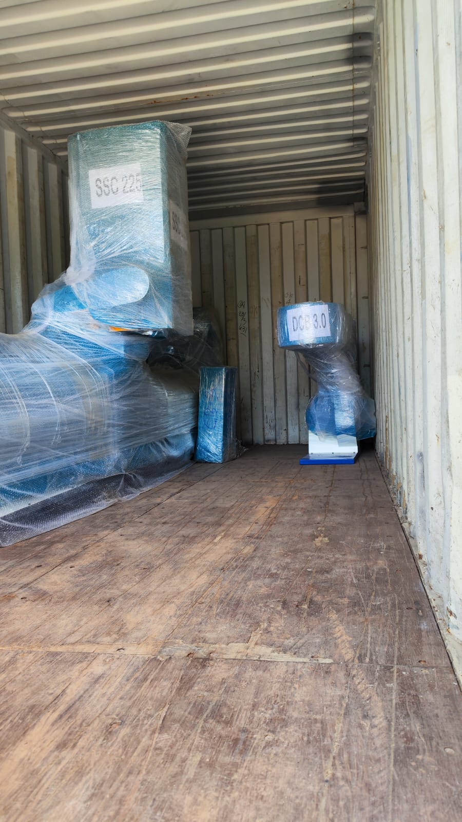 Wrapped machine parts positioned inside a container